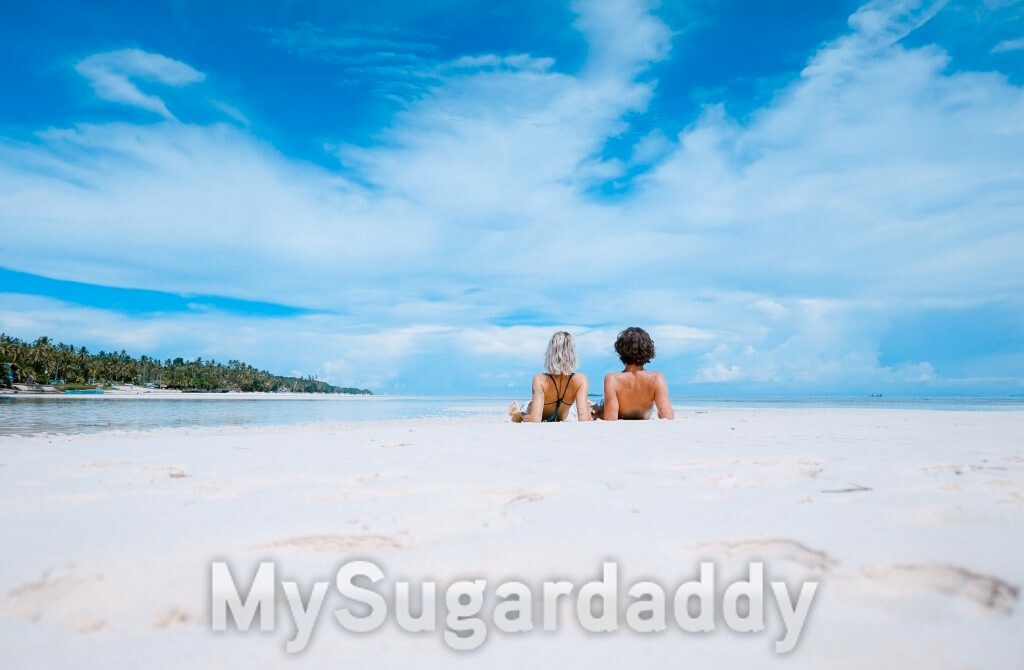 casal sentado na areia de praia pensando em sexo na água